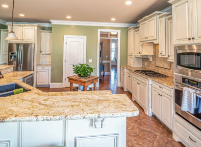 A kitchen with white wooden kitchen cabinets